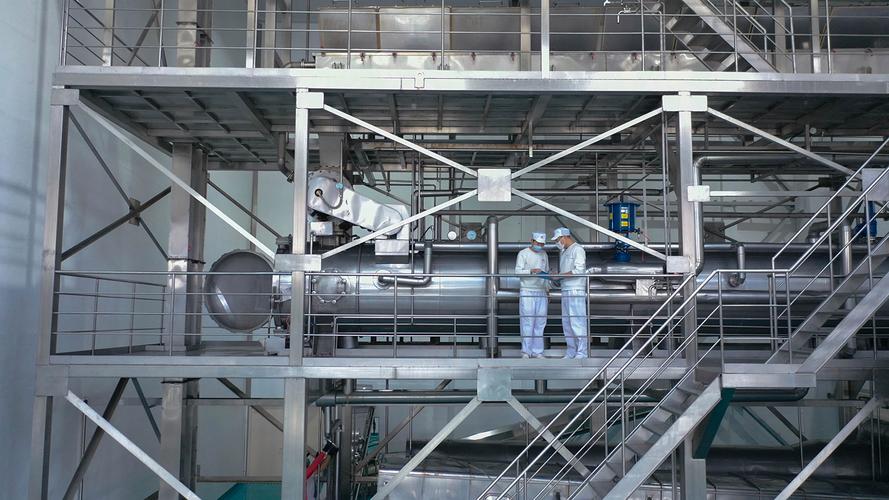 Quality technicians on a stainless steel platform inside the brewery